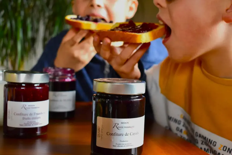 Deux enfants se régalent avec des tartines de confiture Maison Rouge Framboise