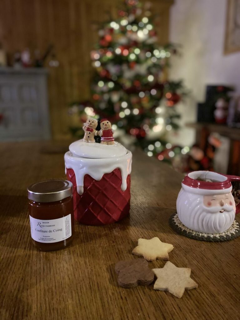 Des cadeaux à savourer en famille 4 Un pot de confiture avec des décorations de Noël et un sapin en fond