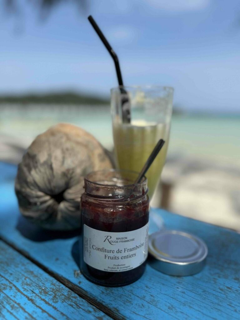 Smoothie et confiture de framboise sur une table bleue à la plage